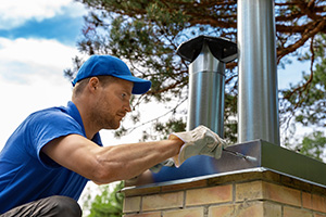 Red Bank chimney service professional working on a chimney cap